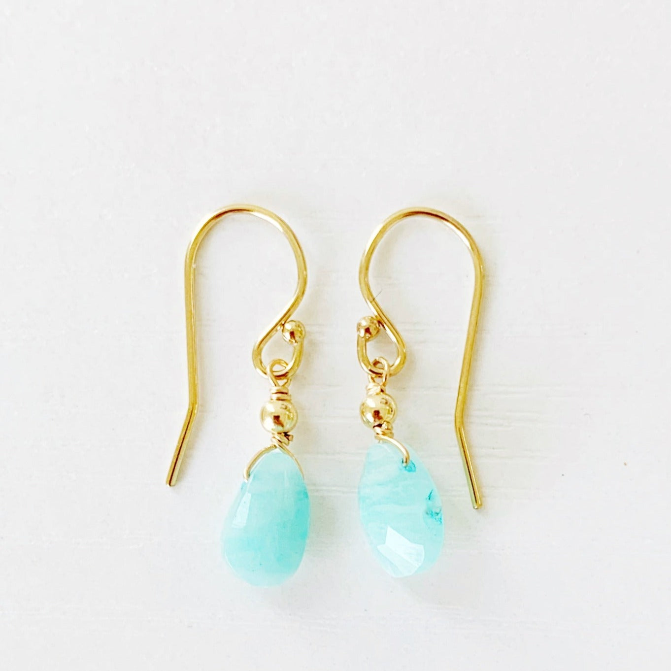 the captiva earring by mermaids and madeleines are dainty earrings with small faceted amazonite briolettes with 14k gold filled findings. this pari is photographed on a white surface