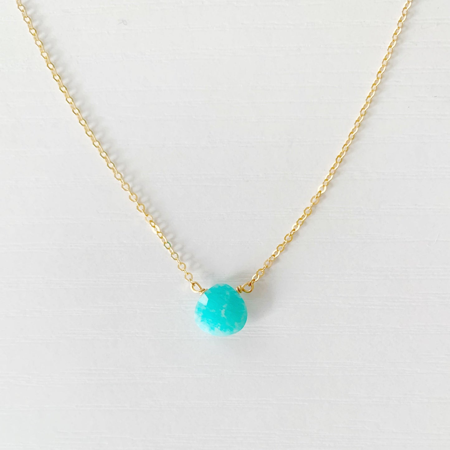 the captiva necklace by mermaids and madeleines is a dainty drop style necklace with a small, faceted, bright teal, amazonite briolette on a 17" 14k gold filled chain.