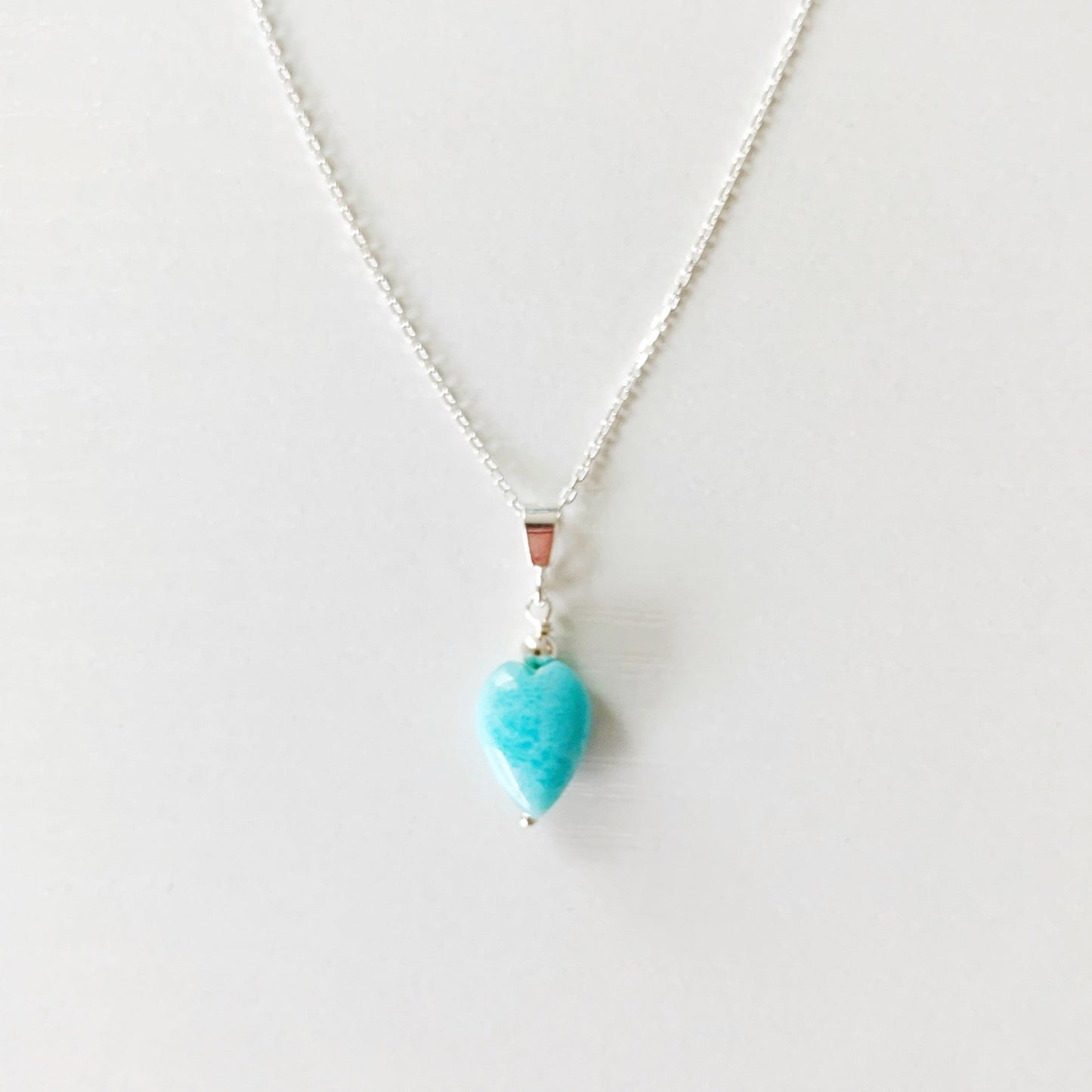 the ocean lover pendant necklace by mermaids and madeleines is created with sterling silver chain and a heart shaped larimar drop. this necklace is photographed on a white background