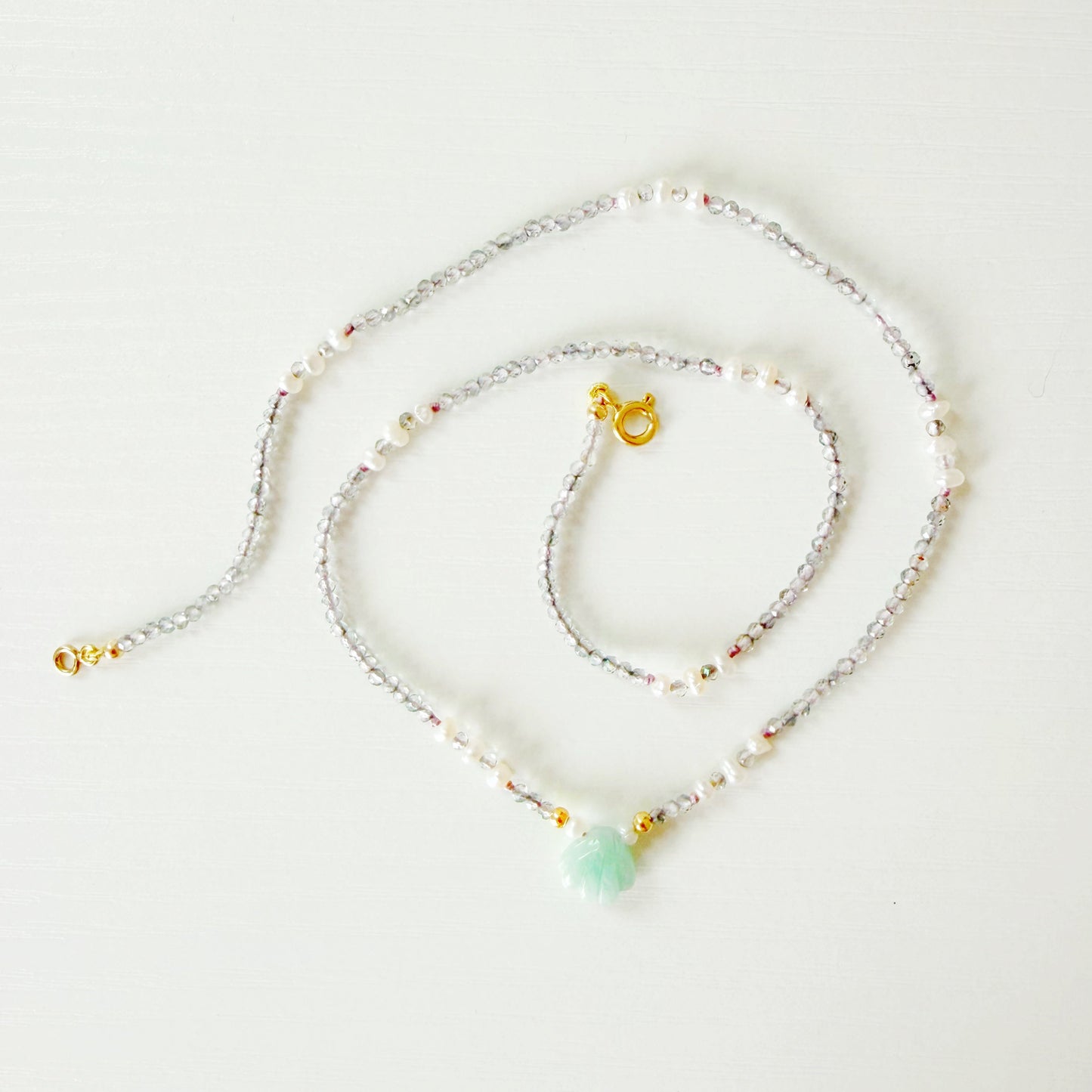a small beaded necklace on a white background