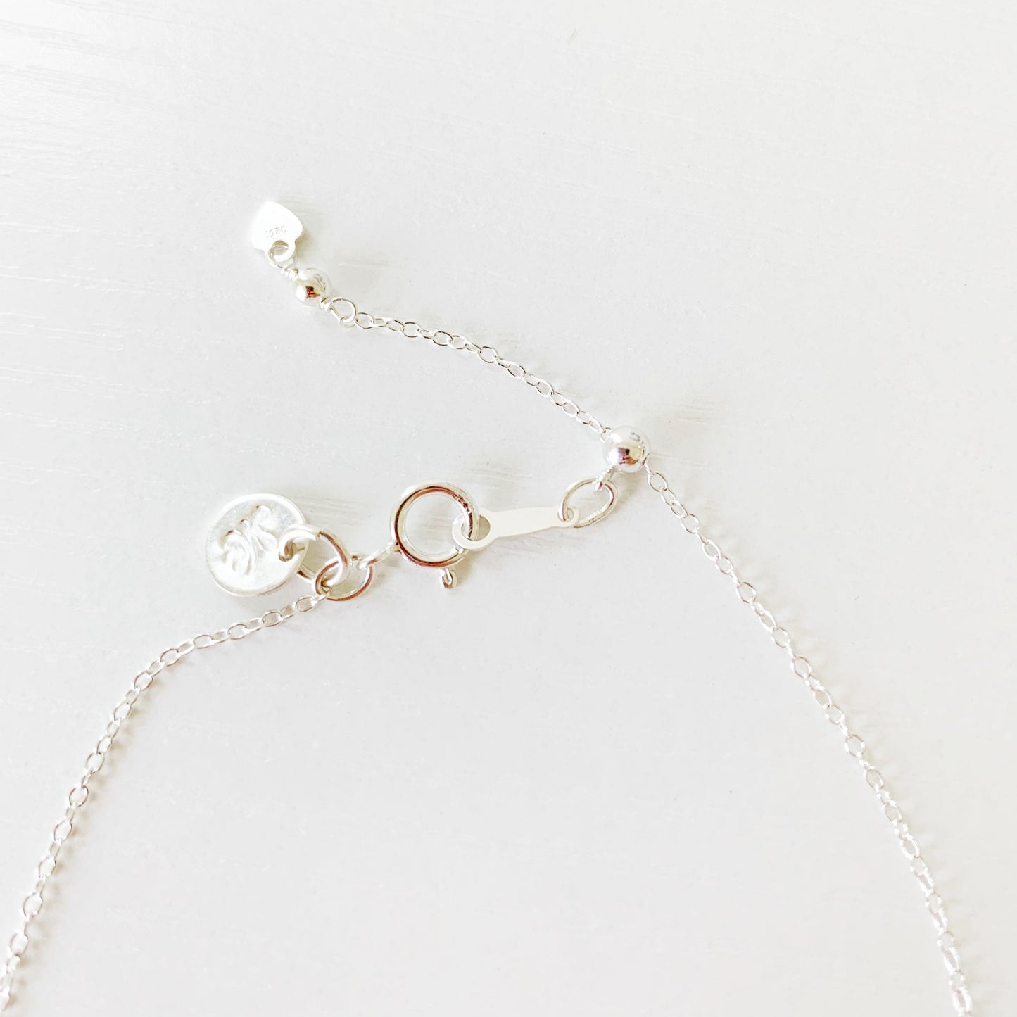 this image shows the back half of the newport bracelet showing the sterling silver chain, slide bead and clasp. its photographed on a white surface
