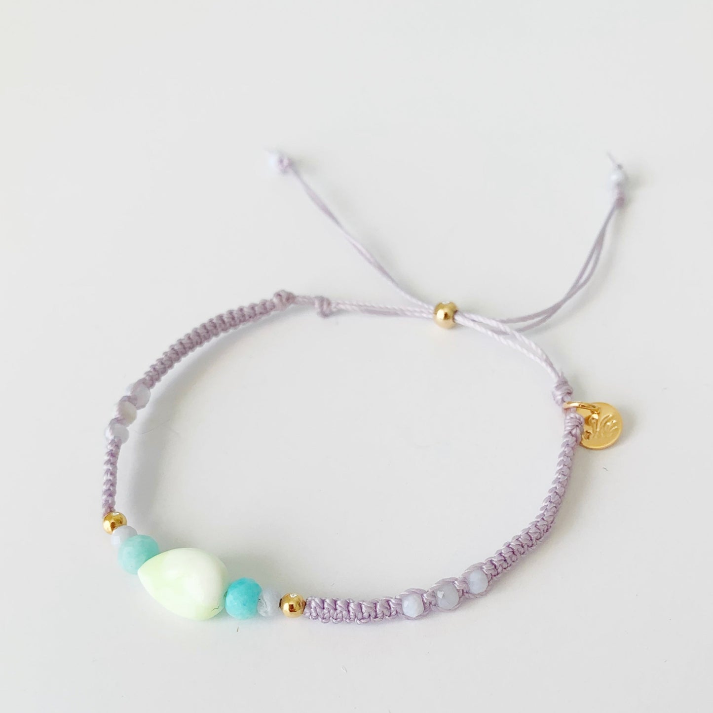 a top view of the coastal haze lavender macrame bracelet photographed on a white backdrop