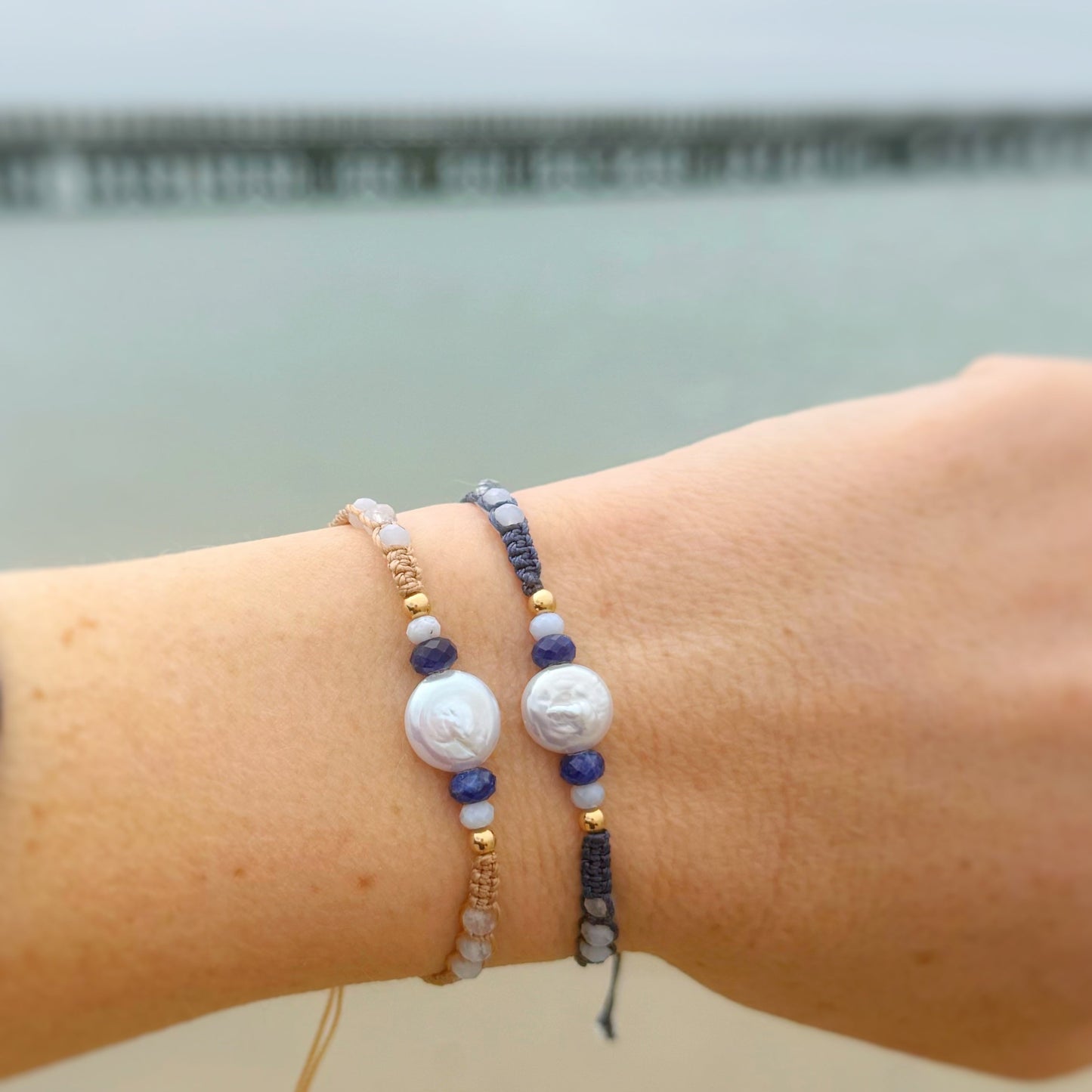 Bracelets on a wrist with a blurred beach background