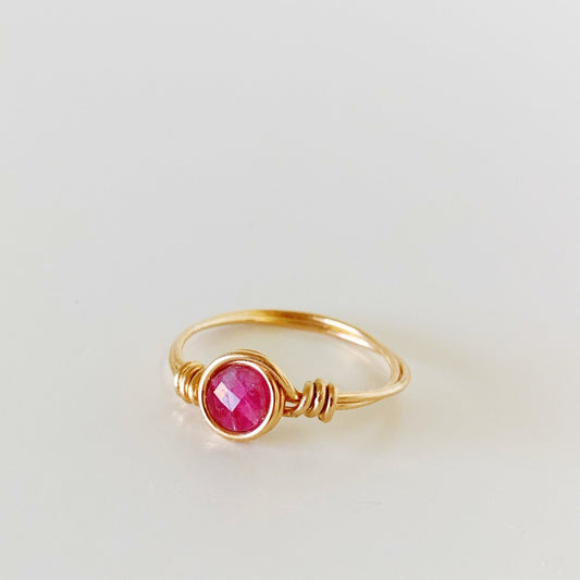 the harwich port ring by mermaids and madeleines is a simple 14k gold filled wire-wrapped ring with a faceted pink tourmaline coin bead at the center. this ring is facing slightly left and photographed on a white surface