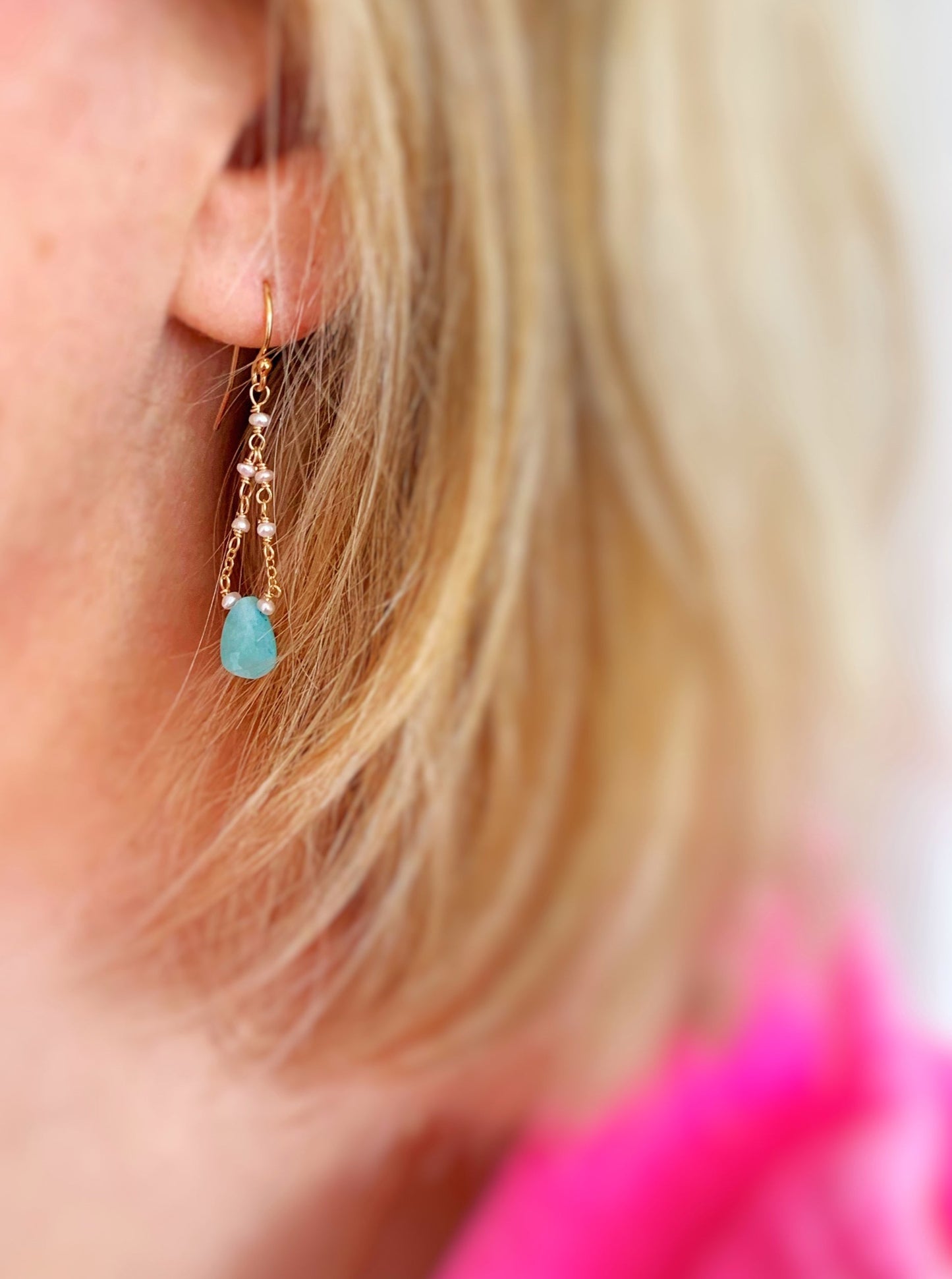 The mermaids and madeleines island air earrings are created with an amazonite teardrop at the center of the drop earrings and chain with freshwater pearls at the top. This is a photo of the earring being worn 