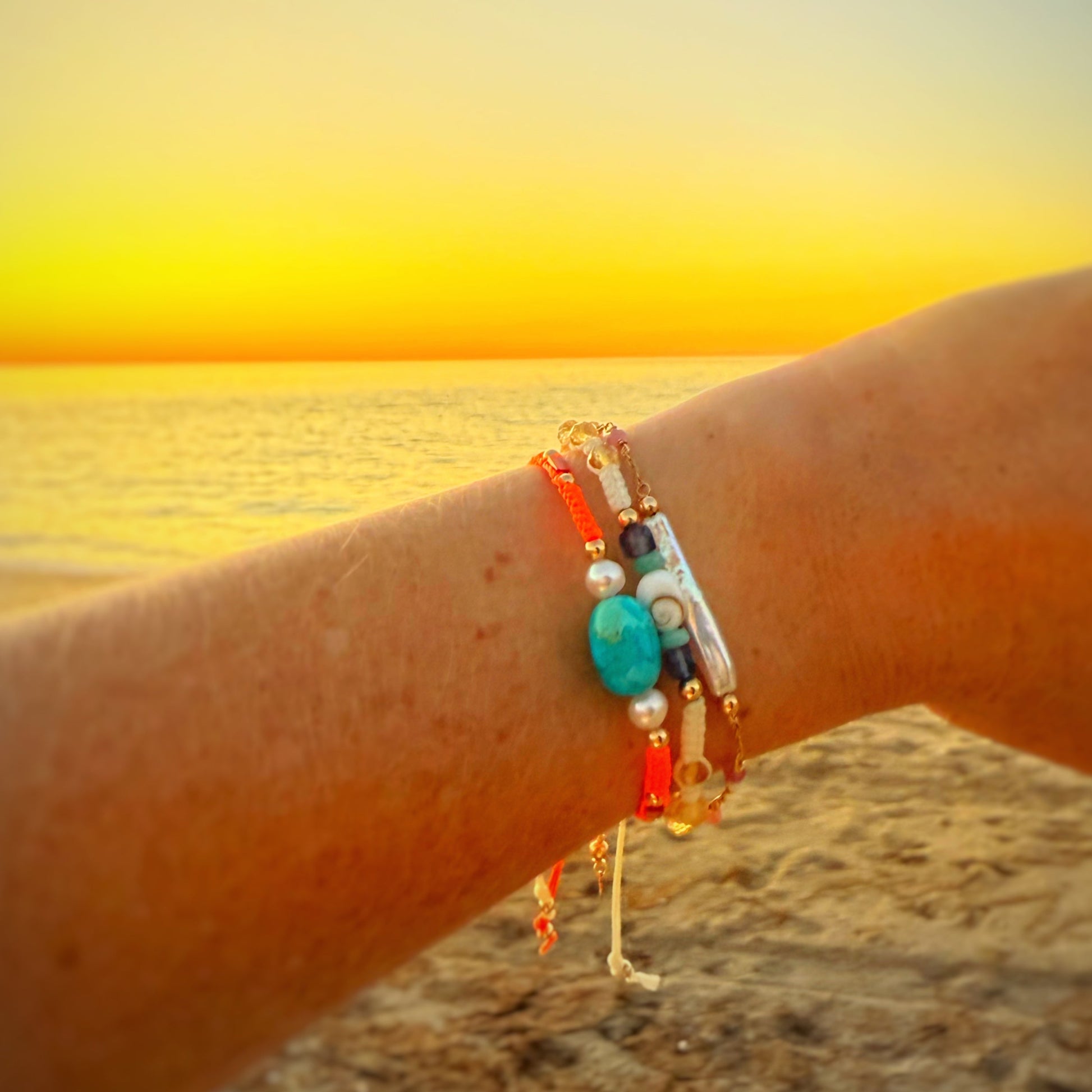 a person wearing a bracelet stack at  the beach