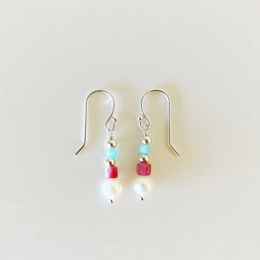 the harwich port earrings by mermaids and madeleines are designed in a petite linear style with freshwater pearl, faceted pink tourmaline, bright amazonite on sterling silver findings. this pair of earrings is photographed flat on a white surface