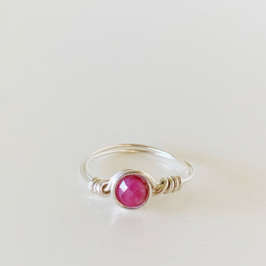 the harwich port ring by mermaids and madeleines is a sterling silver wire wrapped ring with a pink tourmaline faceted coin bead at the center. this ring is facing forward and photographed on a white surface