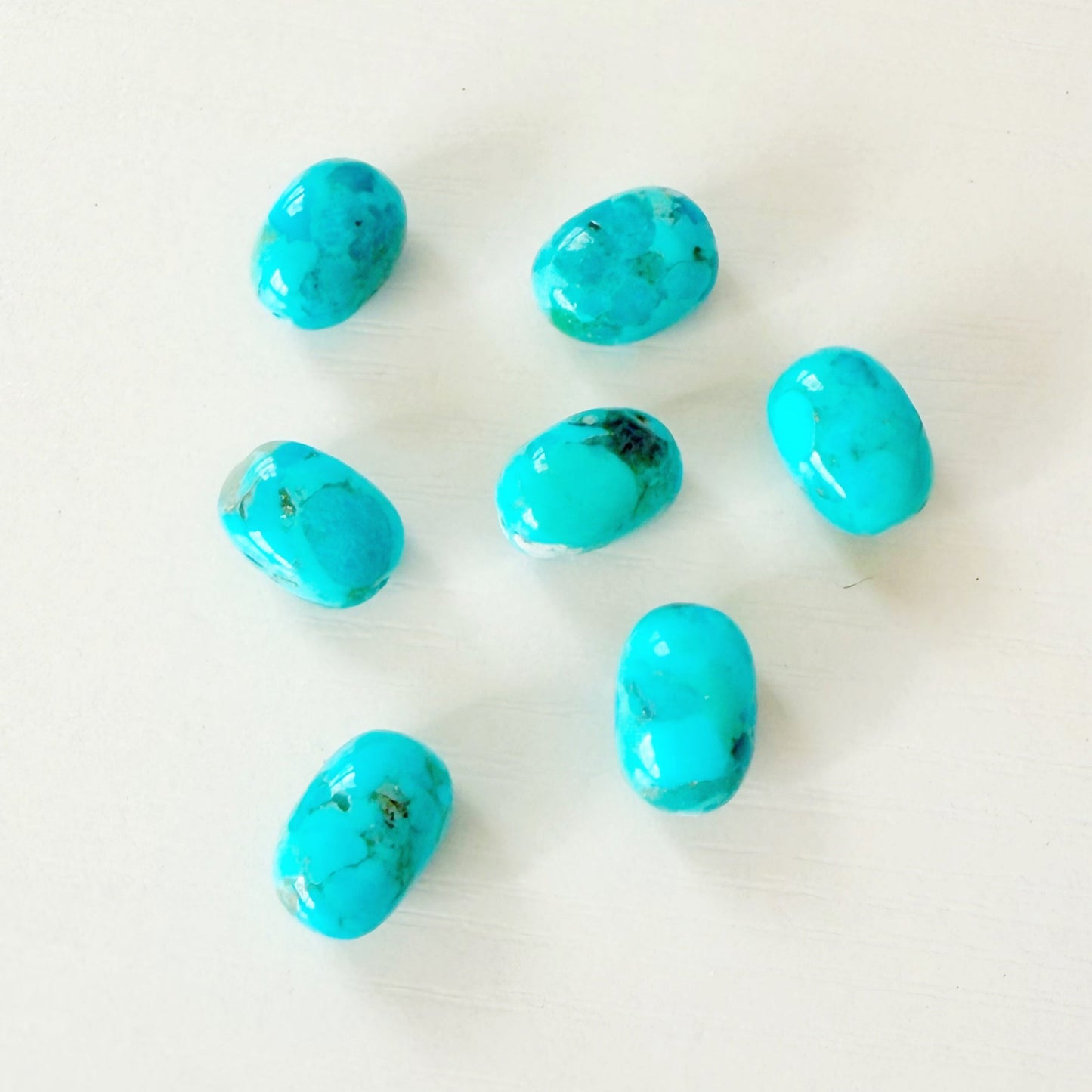 Turquoise beads scattered on a white background