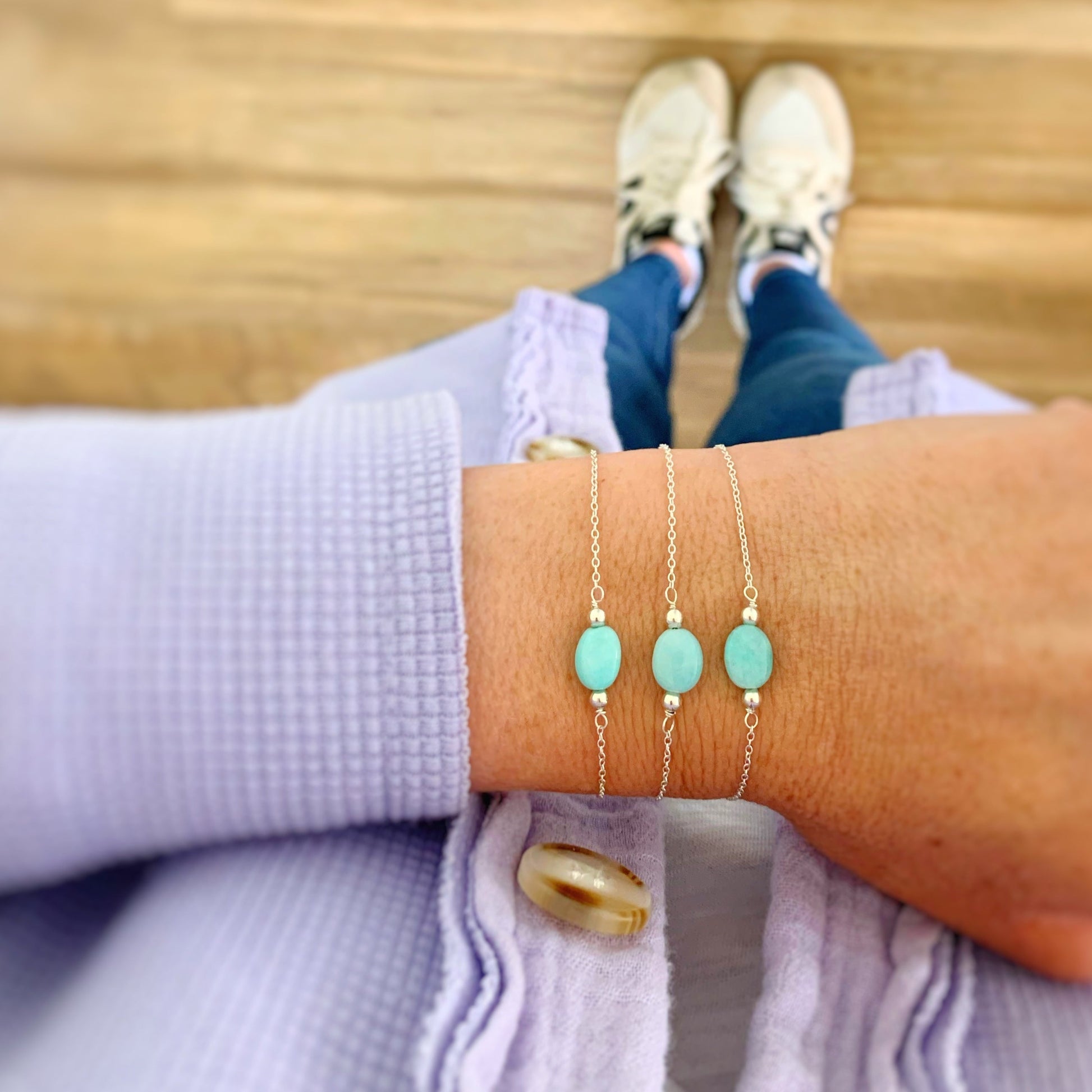 3 laguna bracelets by mermaids and madeleines pictured on a wrist. the bracelets are created with dainty sterling silver chain, bright aqua amazonite and have an adjustable clasp