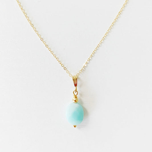 the mermaids and madeleines laguna necklace is created in a pendant style with a faceted oval amazonite bead suspended from 14k gold filled chain and findings. this necklace is photographed flat on a white surface