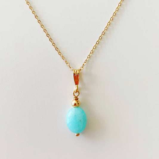 the laguna necklace by mermaids and madeleines is a pendant style necklace with an oval amazonite pendant suspended from 14k gold filled chain and findings. this necklace is photographed on a white surface