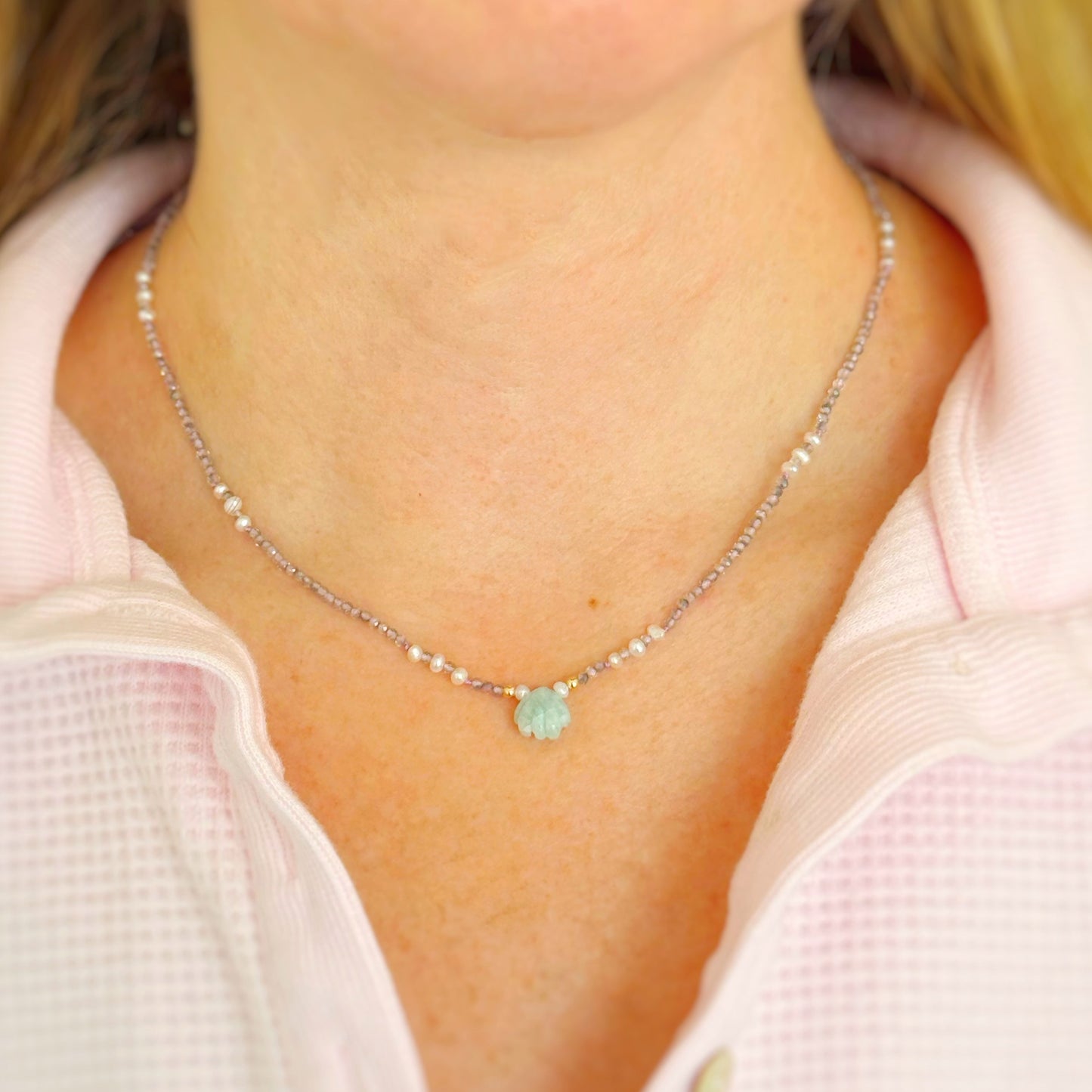 small beaded necklace with a green amazonite shell pendant worn by a person