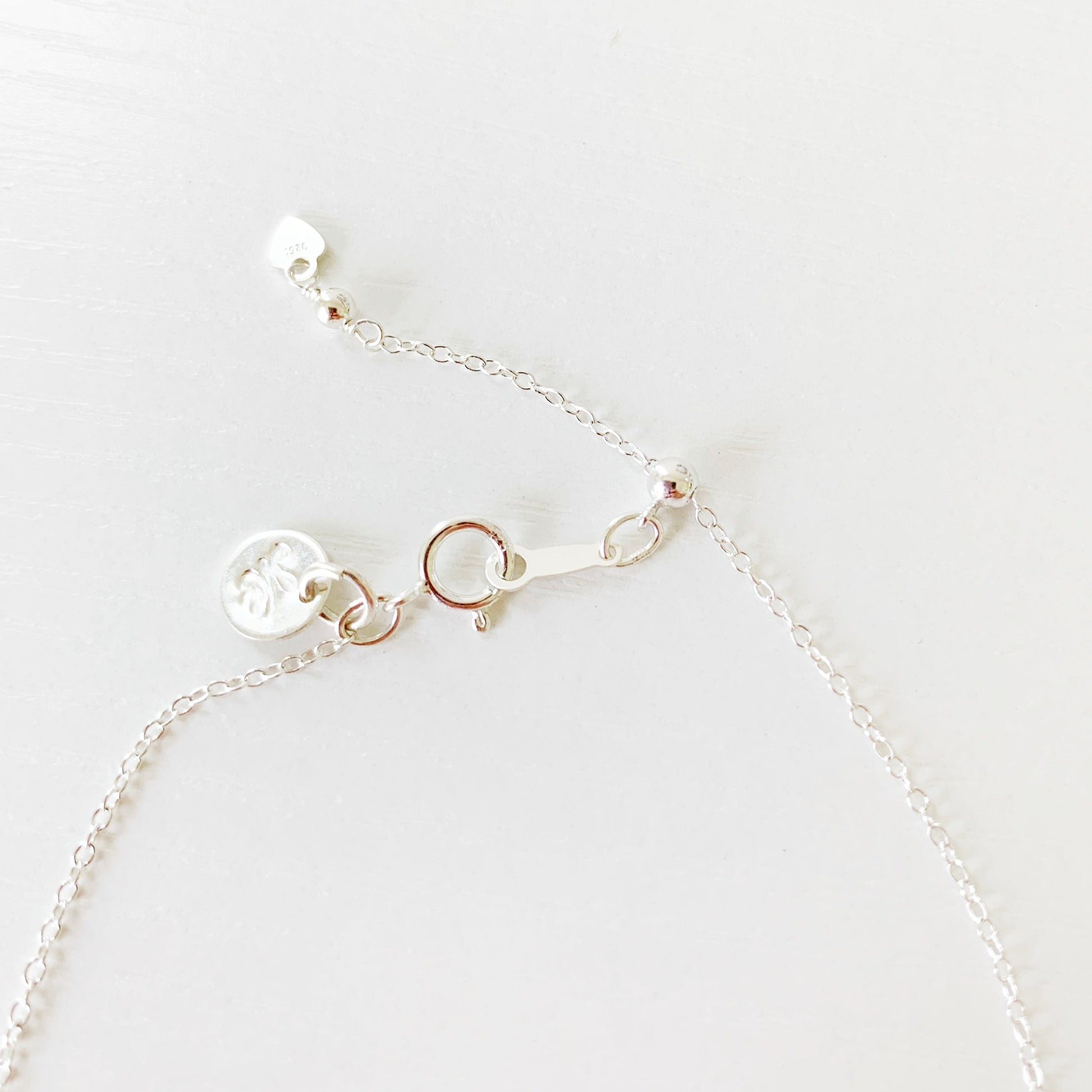 this image shows the back half of the newport bracelet showing the sterling silver chain, slide bead and clasp. its photographed on a white surface