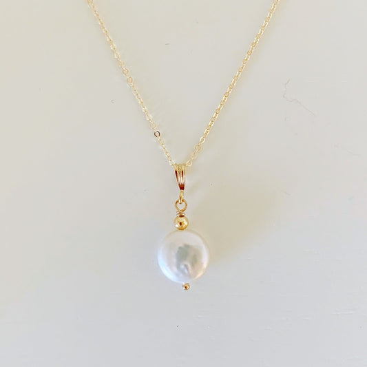the newport necklace by mermaids and madeleines is a simple pendant style designed with a white freshwater coin pearl and 14k gold filled chain and findings