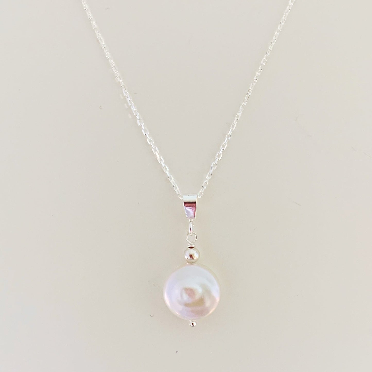 the newport necklace by mermaids and madeleines is a simple style pendant designed with a white freshwater coin pearl and sterling silver chain and findings