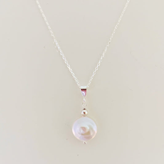 the newport necklace by mermaids and madeleines is a simple style pendant designed with a white freshwater coin pearl and sterling silver chain and findings