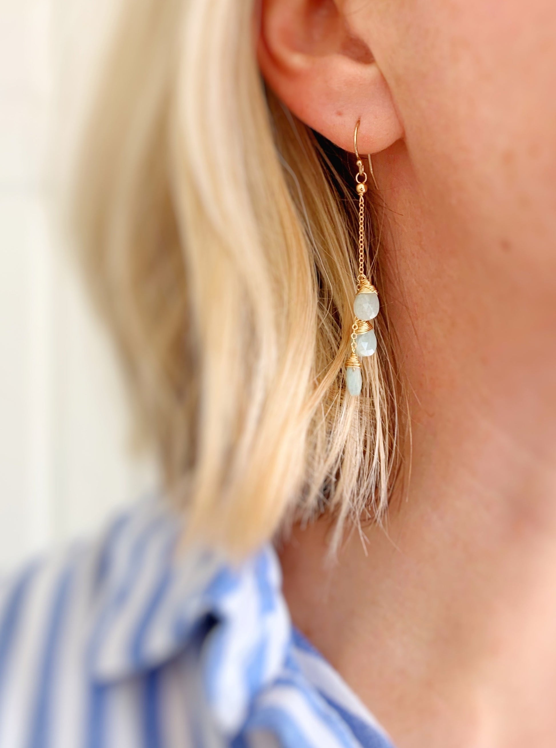The raindrop earring is pictured here on a person's ear to show wearability