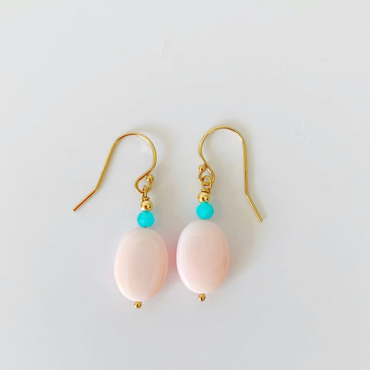 sanibel earrings are created with oval pink conch shell complimented by small amazonite beads on 14k gold filled findings. this pair is pictured on a white surface