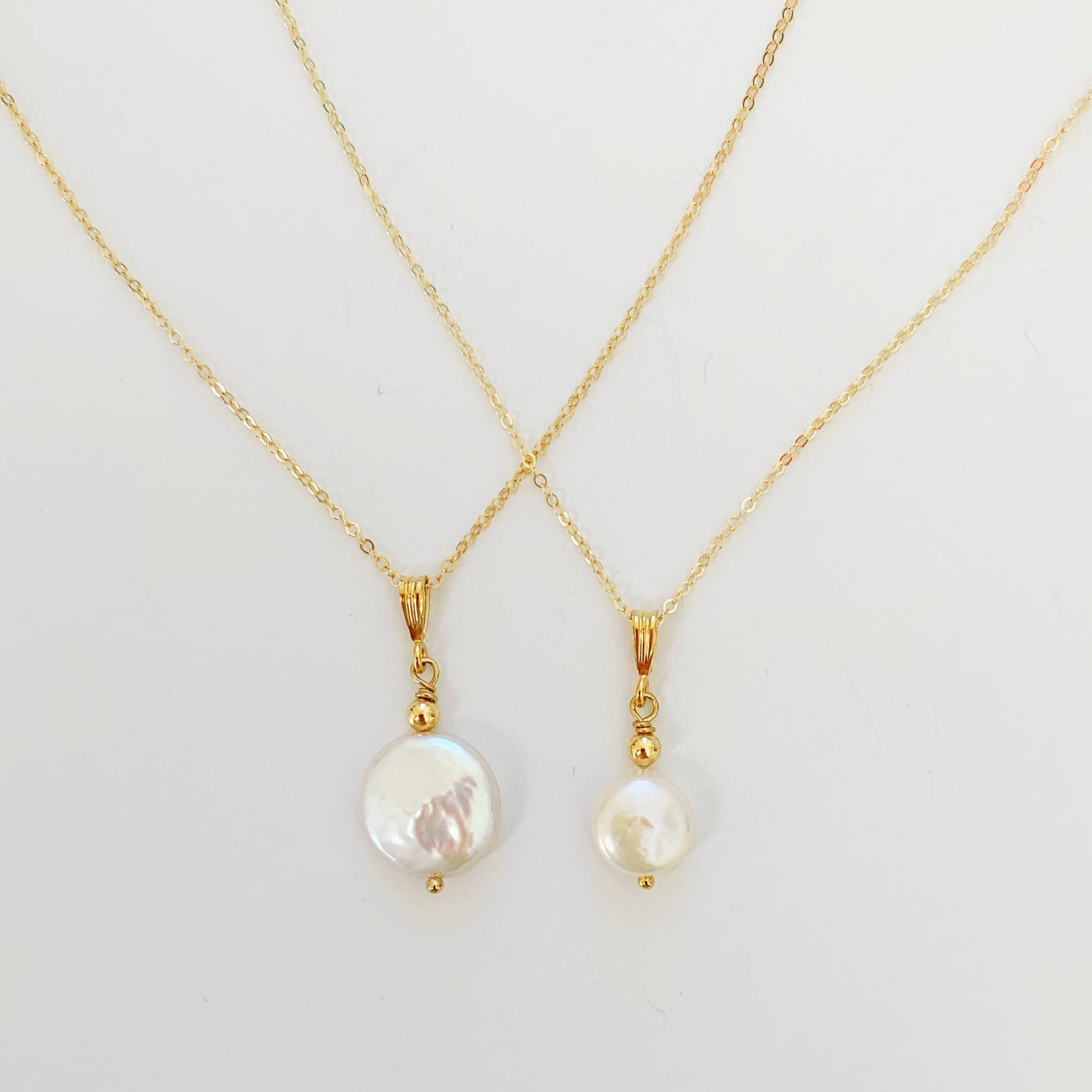 The newport gala necklace and newport original necklace pictured next to each other on a white surface for size comparison
