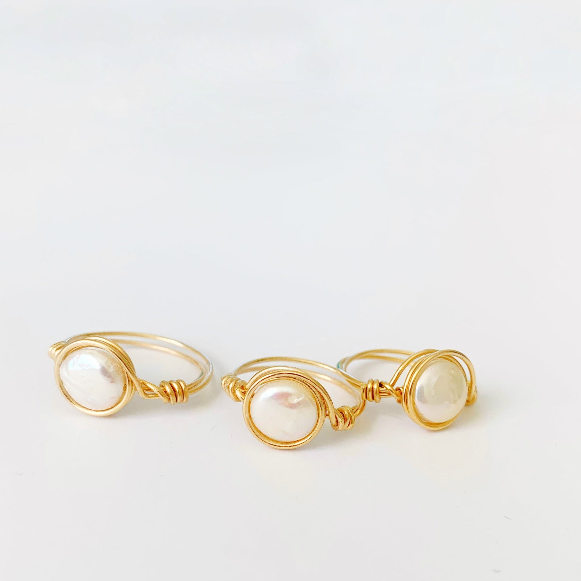 3 newport pearl wire wrapped rings in 14k gold filled and freshwater coin pearls. Pictured here on a white surface