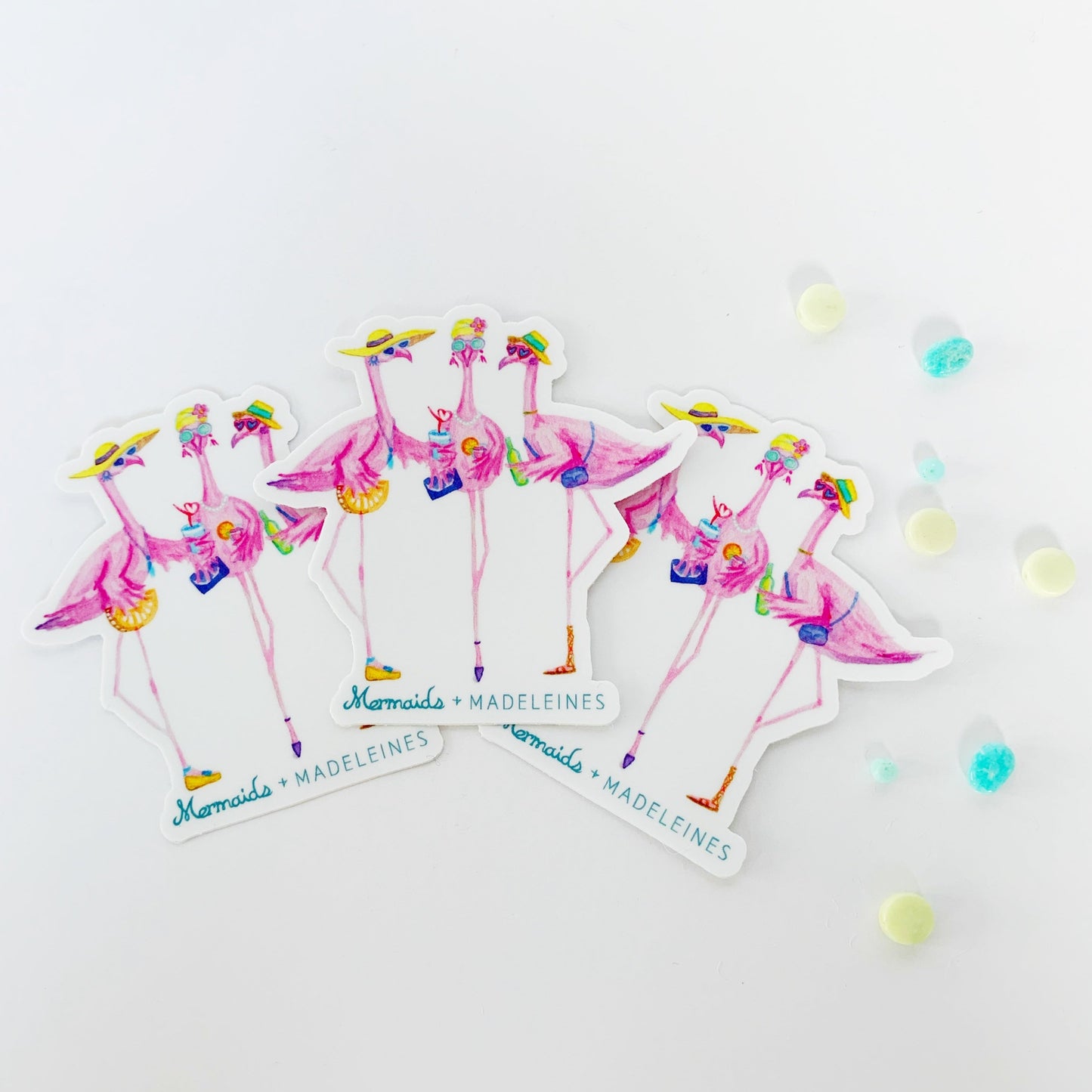 The flamingal sticker is created from original artwork made with acrylic paint and marker its 3 flamingo ladies dressed in summer hats and various footwear. This is a picture of the 3 pack, three stickers fanned out on a white background