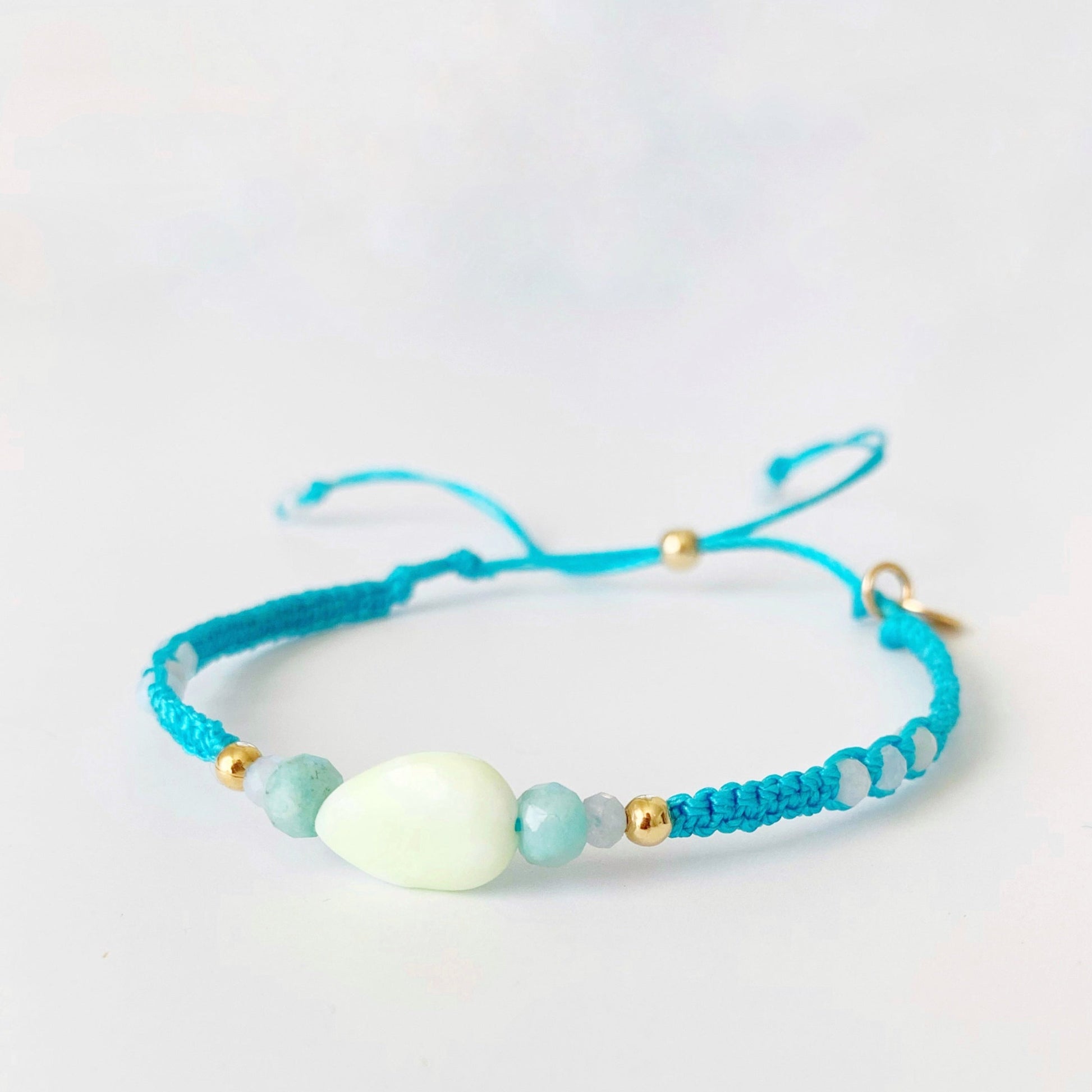 a semi side view of the blue crush captiva macrame bracelet photographed on a white surface