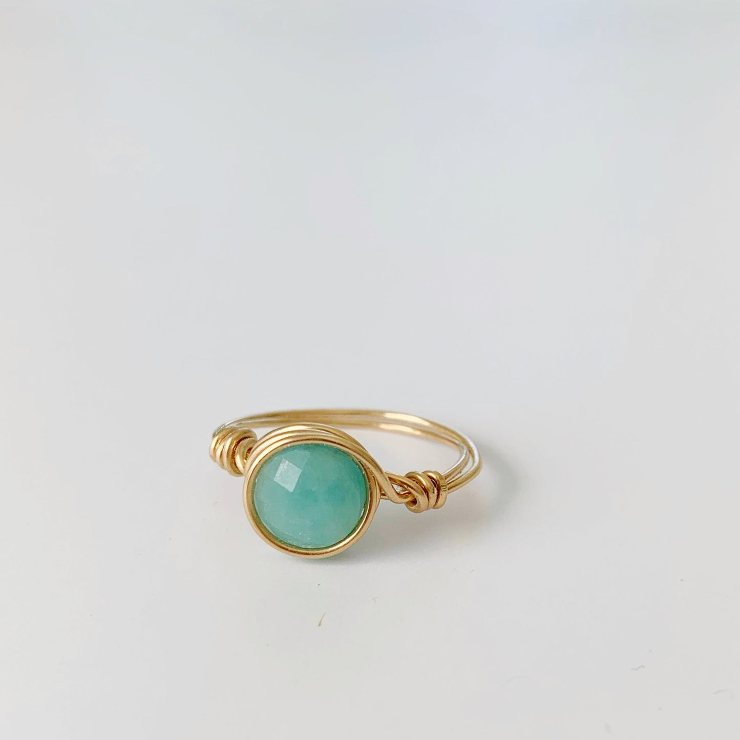 Mermaids and Madeleines Captiva Wire Wrapped ring in 14k gold filled metal with an amazonite gem. This ring is pictured on a white surface