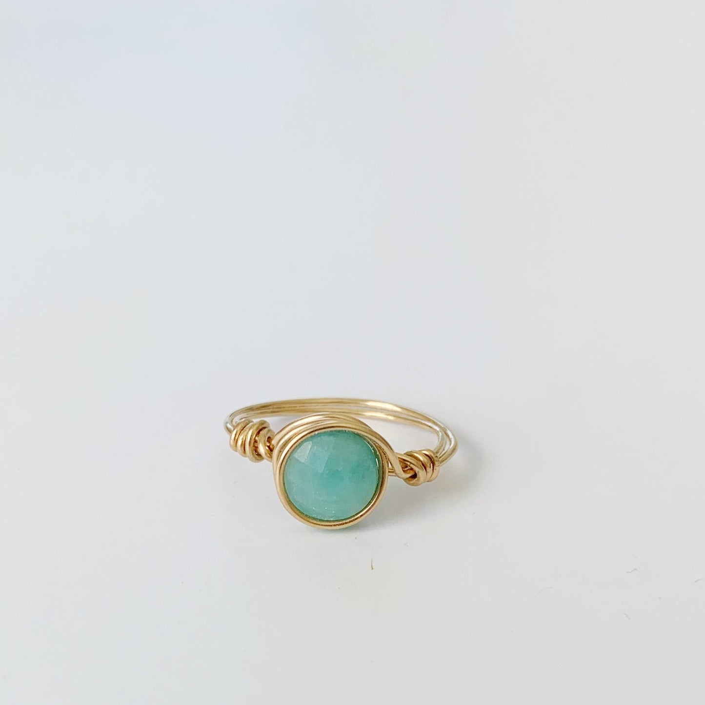 Mermaids and Madeleines Captiva Wire Wrapped ring in 14k gold filled wire with a bright amazonite gem. This ring is photographed on a white surface
