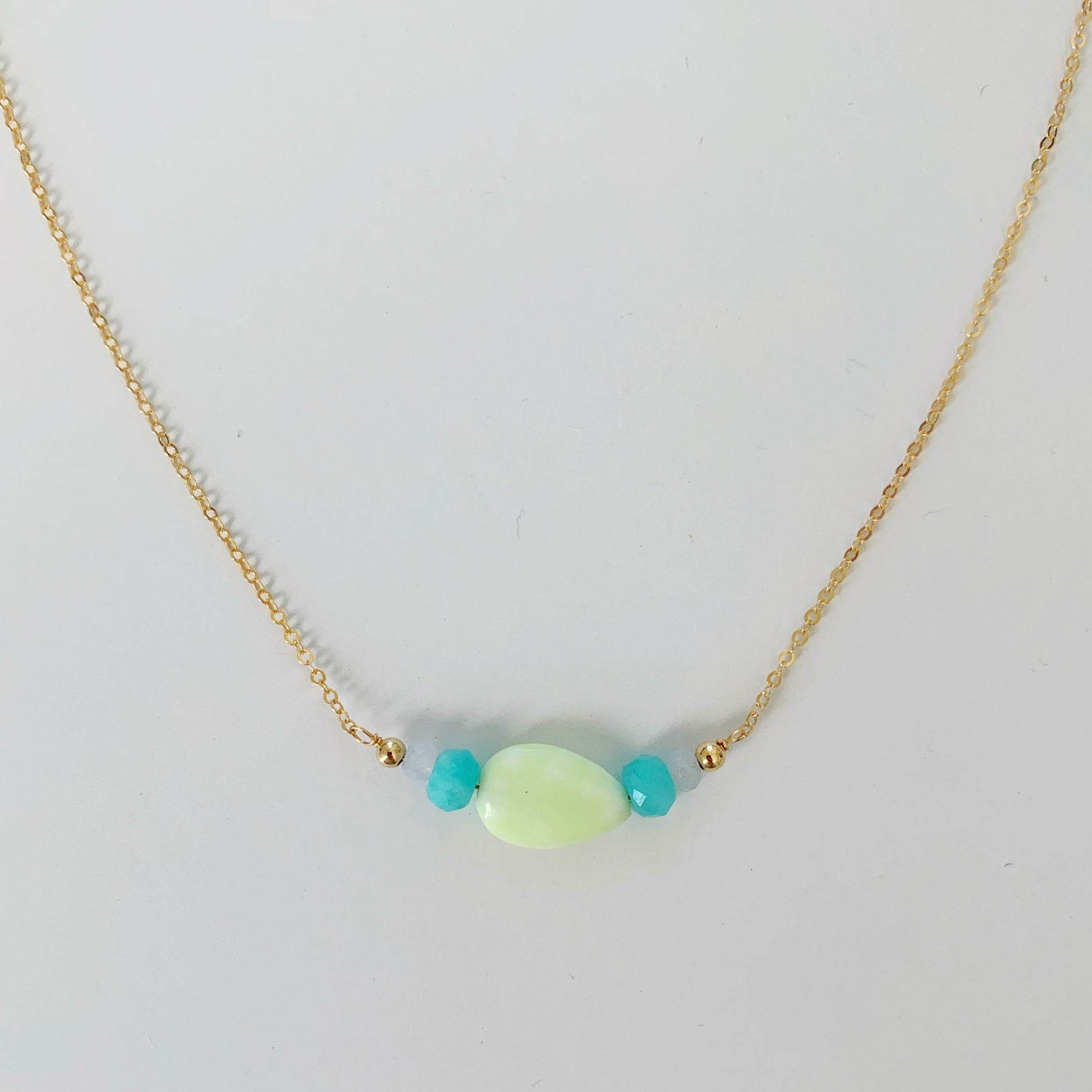 Captiva Necklace by mermaids and madeleines is created with a teardrop lime jade bead with amazonite and blue lace agate on 14k gold filled chain. this necklace is photographed on a white surface