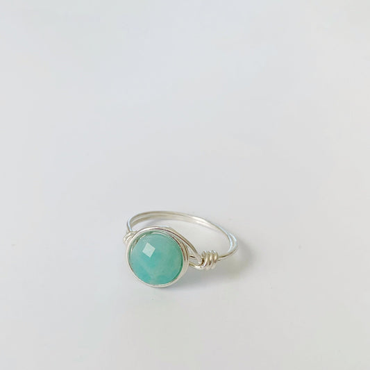 Captiva Ring by mermaids and madeleines is a sterling silver wire wrapped ring with an amazonite gem at center. this ring is photographed on a white surface