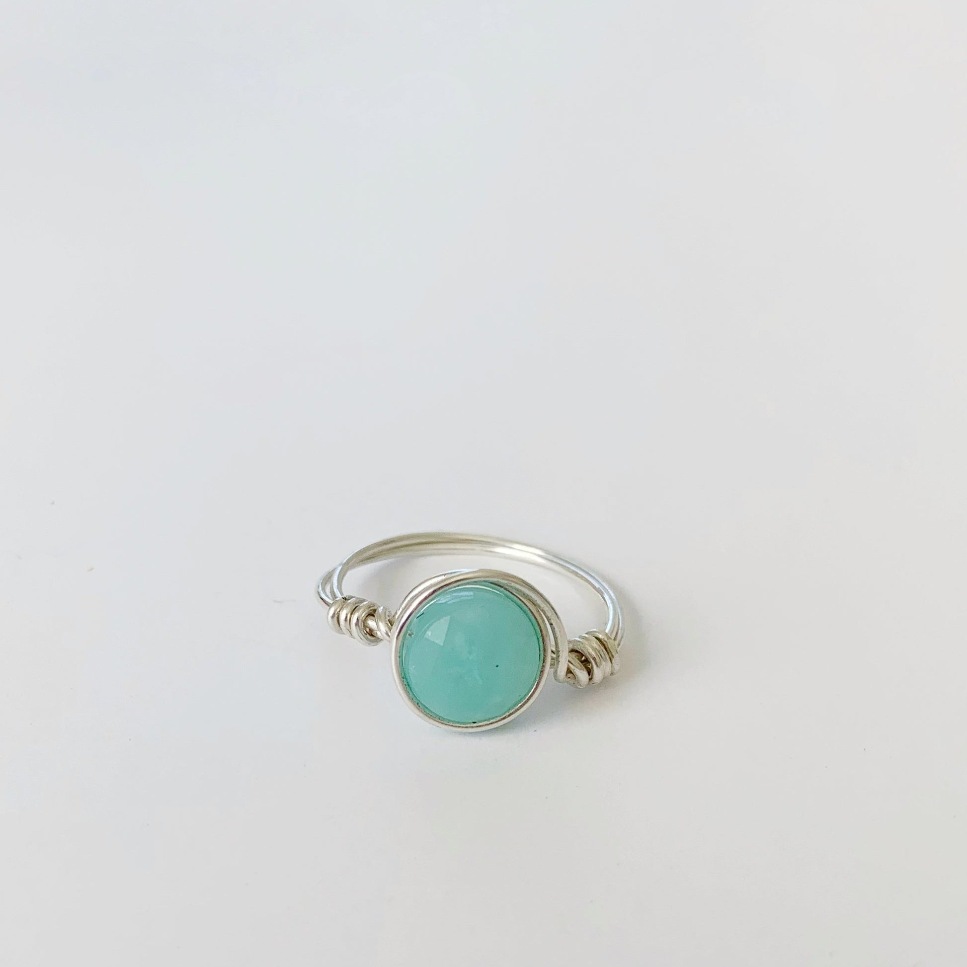 Mermaids and Madeleines Captiva Ring in sterling silver is a wire wrapped ring with an amazonite bead. this ring is pictured on a white surface