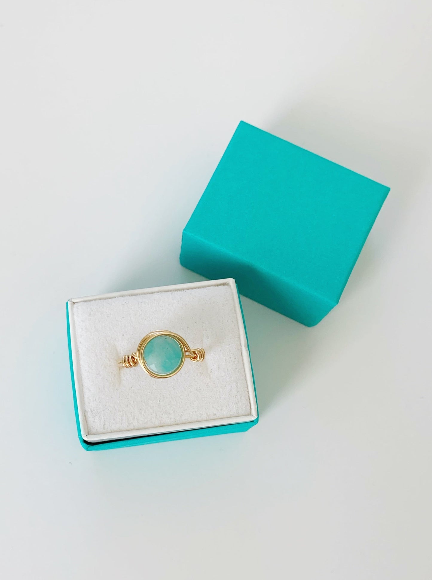 Mermaids and madeleines Captiva ring is a 14k gold wire wrapped ring with amazonite gem. This ring is photographed in a teal gift box on a white surface