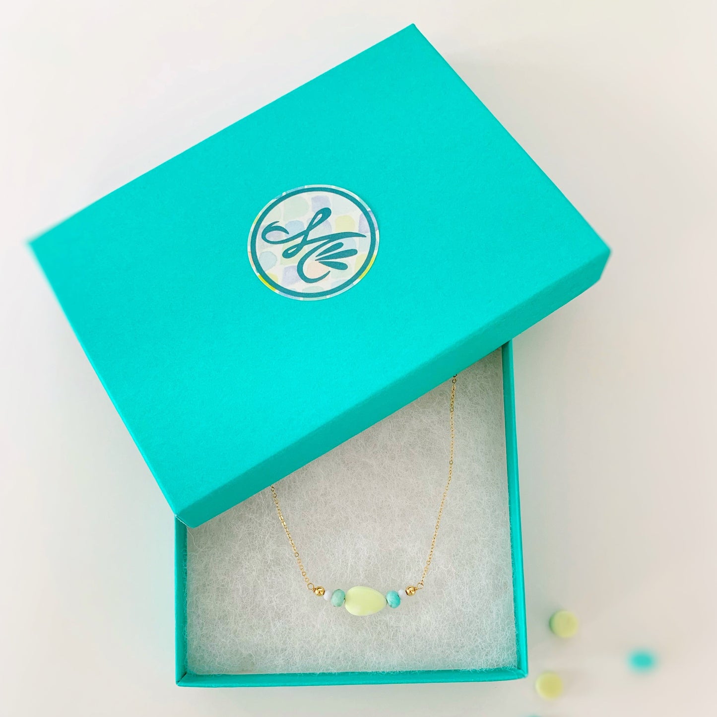 Captiva necklaced pictured in a Mermaids and Madeleines branded box that's cotton lined and teal color. photographed on a white background