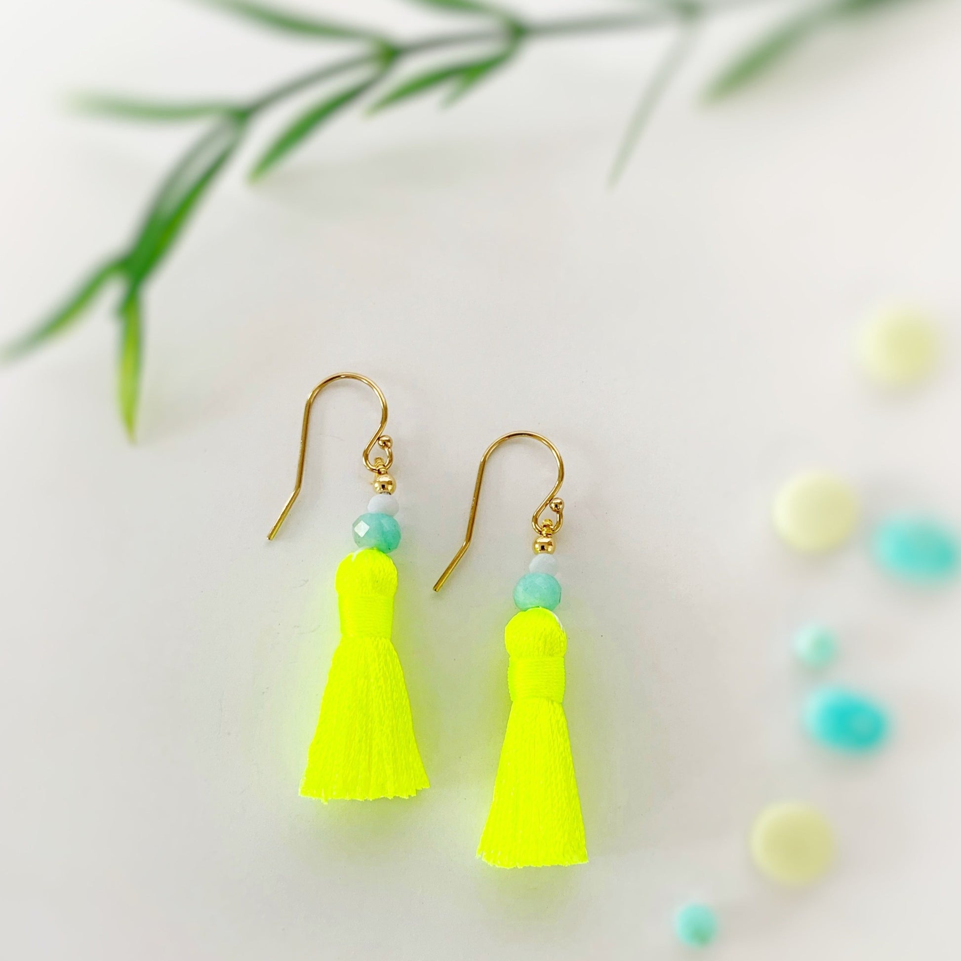 Captiva tassel earrings are from the mermaids and madeleines sunshine collection. They feature bright neon yellow tassels and amazonite and blue lace agate beads and 14k gold filled earring findings. This pair is photographed on a white background with a little bit of blurred greenery near the top of the photo for added interest in the composition of the photo