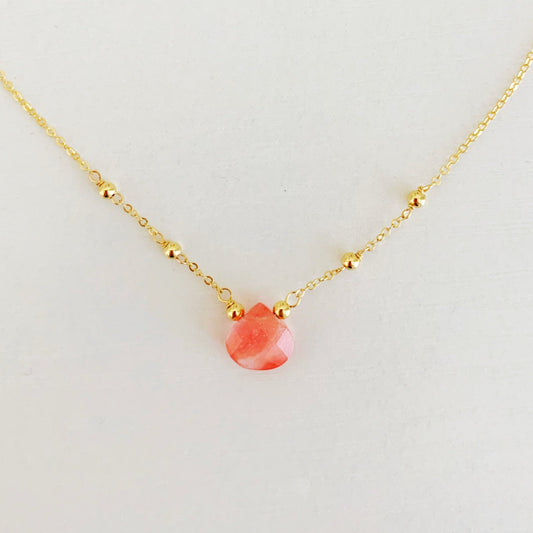Chatham Necklace by Mermaids and Madeleines features a cherry quartz briolette drop and 14k gold filled beads, findings and chain. This one is photographed close up on a white surface