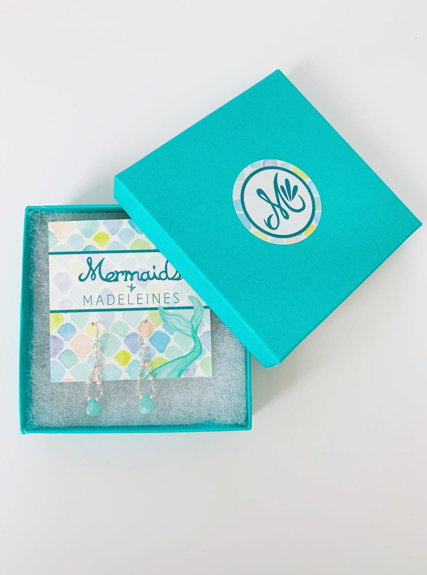 Island Air Earrings by mermaids and madeleines photographed in a teal gift box with white cotton lining. The earrings are on a card and created with amazonite teardrop gems, sterling silver and freshwater pearls