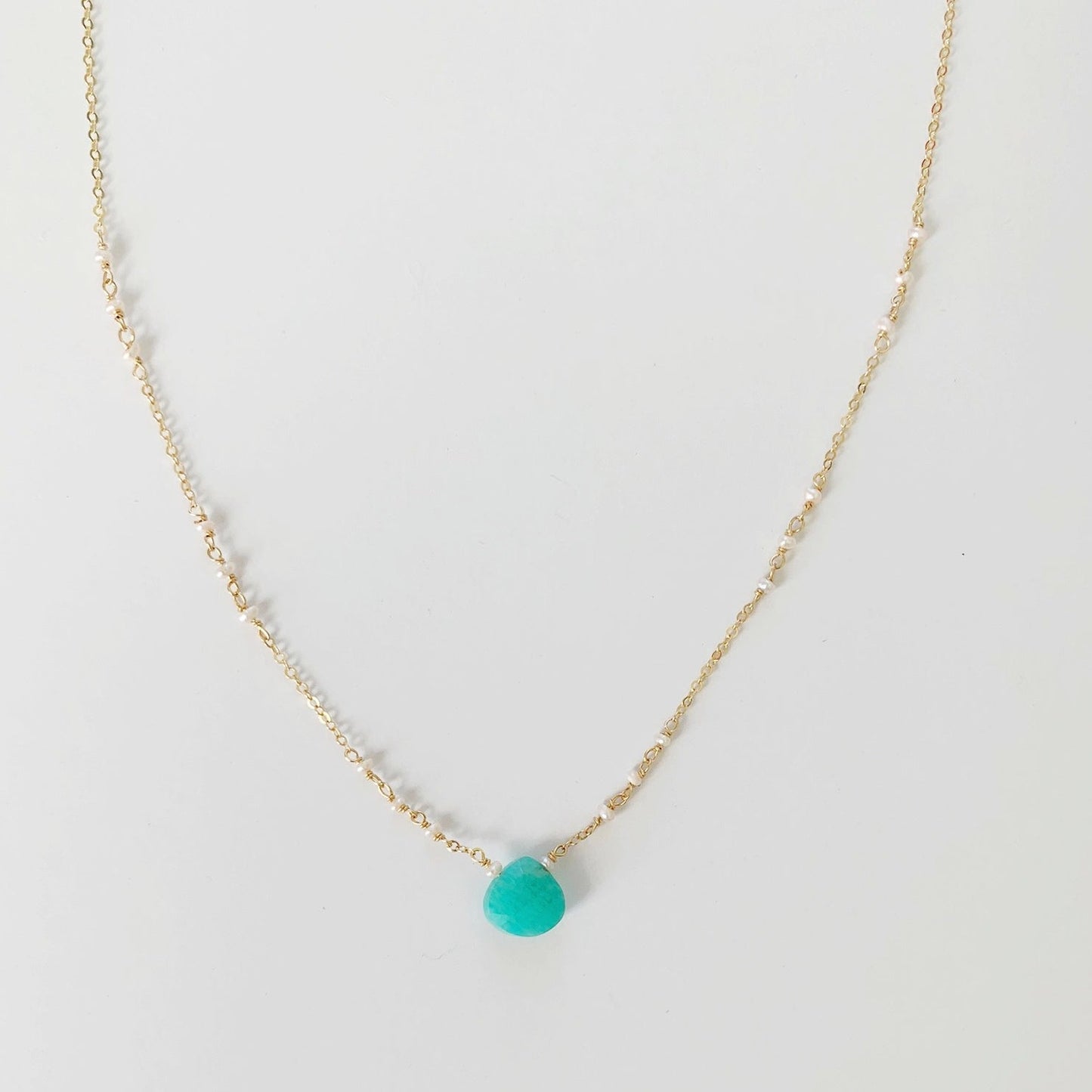 Island Air Necklace by mermaids and madeleines is created with a bright amazonite gem at the center and tiny freshwater pearls on 14k gold filled chain. this necklace is photographed on a white background