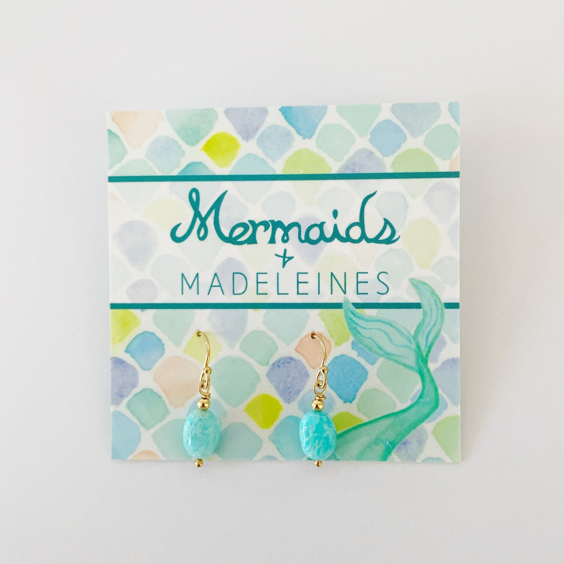 The laguna earrings in 14k gold filled. This pair is created with 14k gold filled beads and findings and bright aqua oval shaped beads. This pair is pictured on a mermaids and madeleines earring card and photographed on a white background