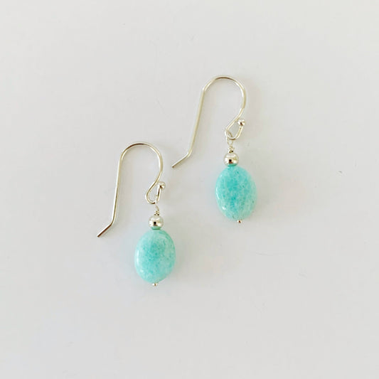 The laguna earrings in sterling silver. This pair of earrings is created with sterling silver beads and findings and bright aqua amazonite beads. This pair is photographed on a white background