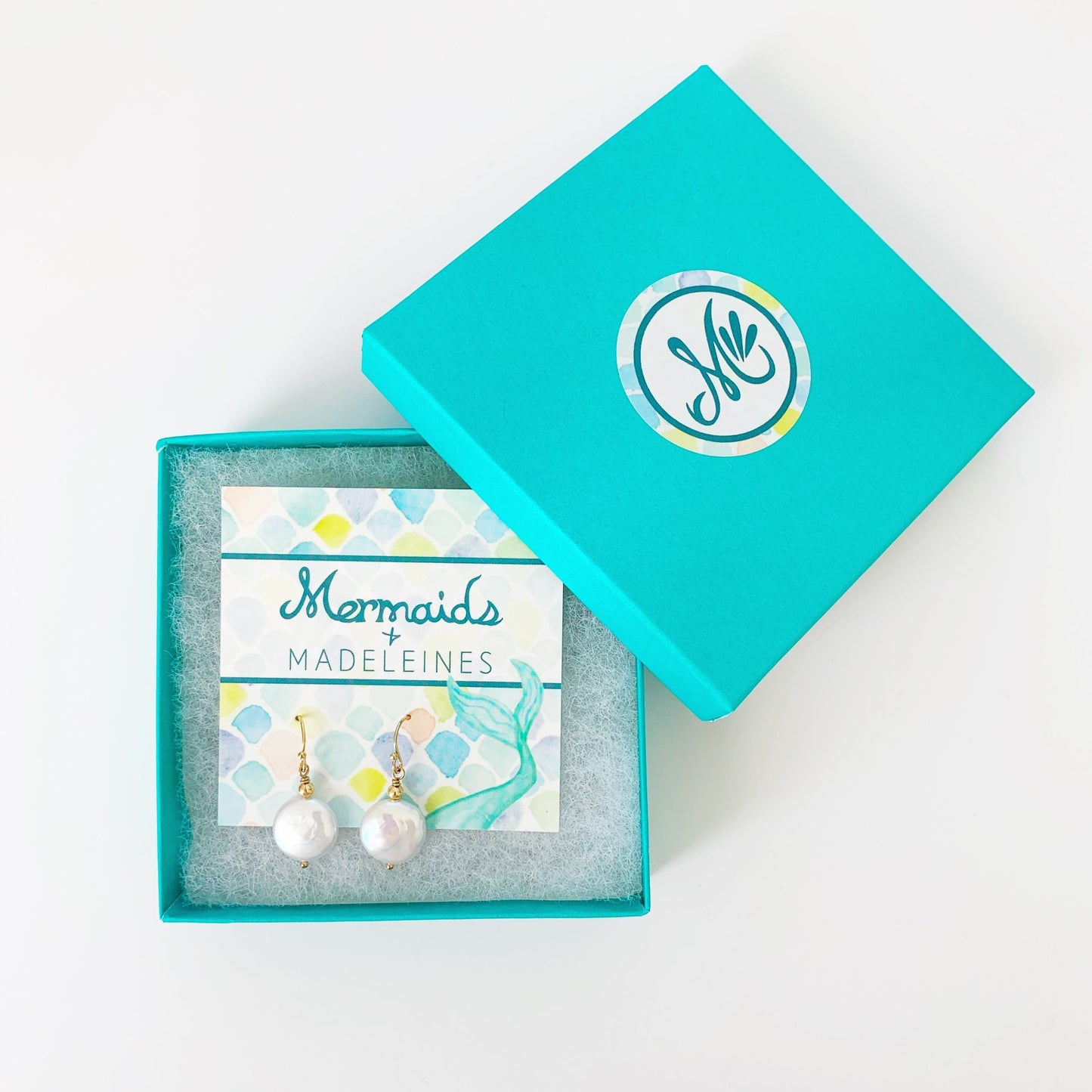 Newport Gala earrings in gold filled pictured carded in a teal gift box on a white surface