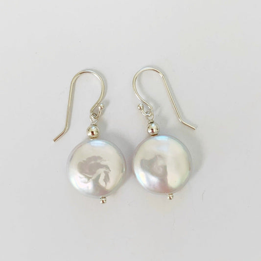 Newport Gala Sterling Silver Earrings by mermaids and madeleines feature large freshwater coin pearls and sterling silver findings. this pair is pictured on a white surface