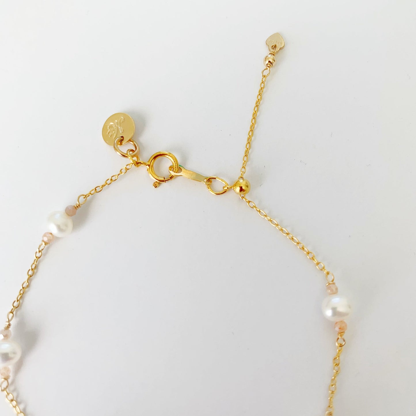 The back of the barrinton bracelet shows that it has a spring ring clasp and a slide bead to adjust the bracelet length. This is pictured over a white background
