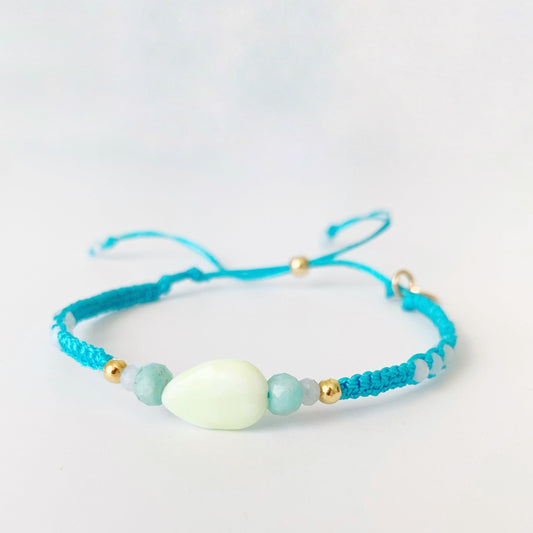 Bright Blue Crush Captiva macramé bracelet by mermaids and madeleines has lime jade, amazonite and blue lace agate beads at the center with 14k gold filled slide bead. this bracelet is photographed on a white surface