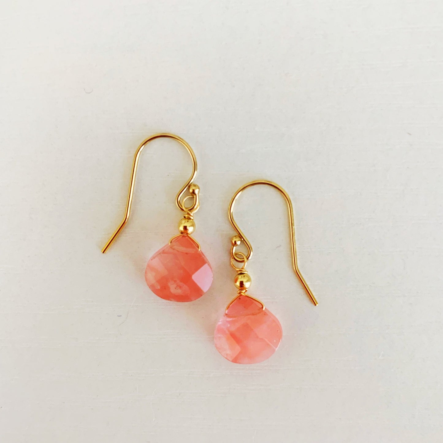 Chatham Earrings by Mermaids + Madeleines feature cherry quartz faceted drops and 14k gold filled findings. This pair is photographed on a white background