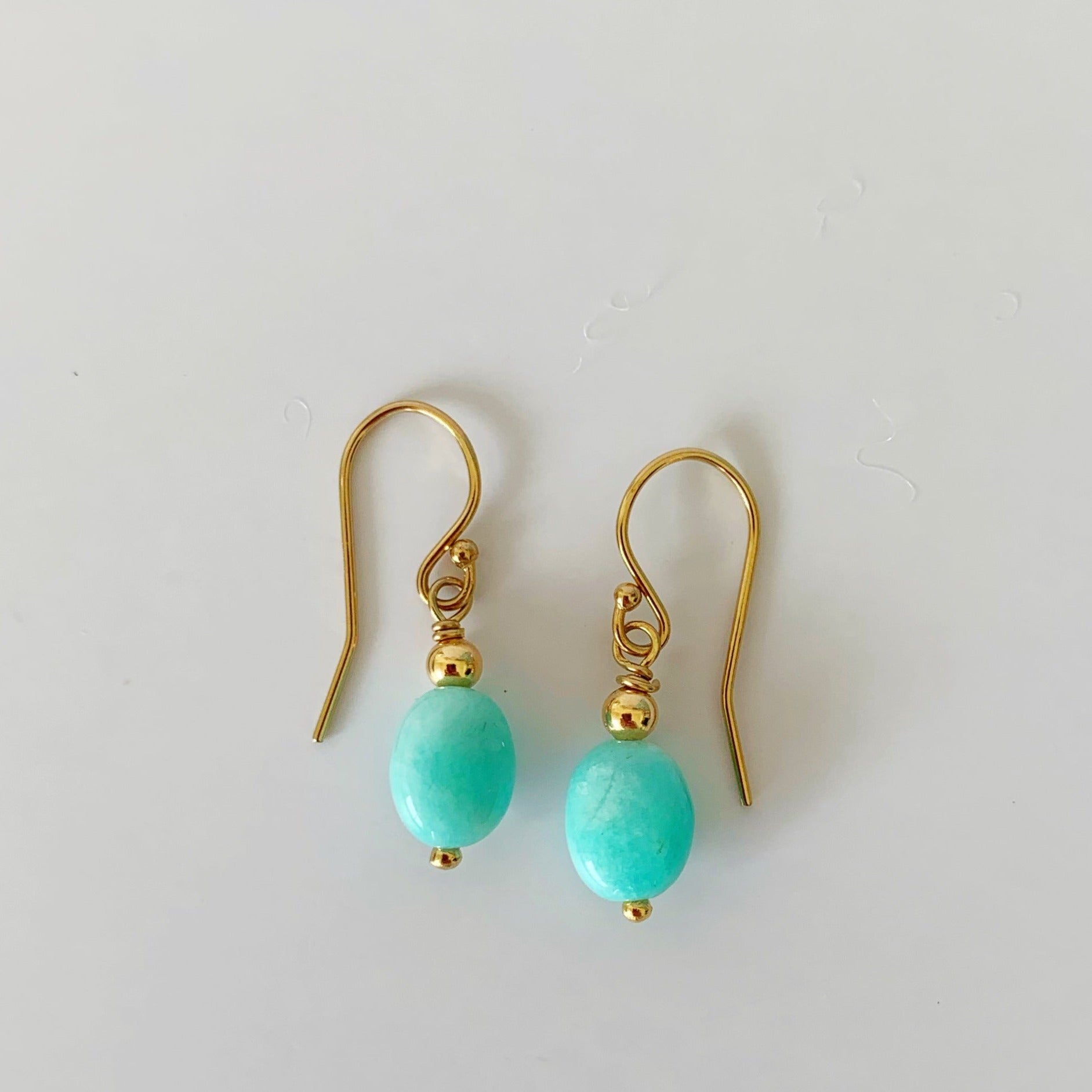 Mermaids and madeleines laguna earrings are created with amazonite ovals and 14k gold filled beads and findings. This pair of drop style earrings is photographed on a white background