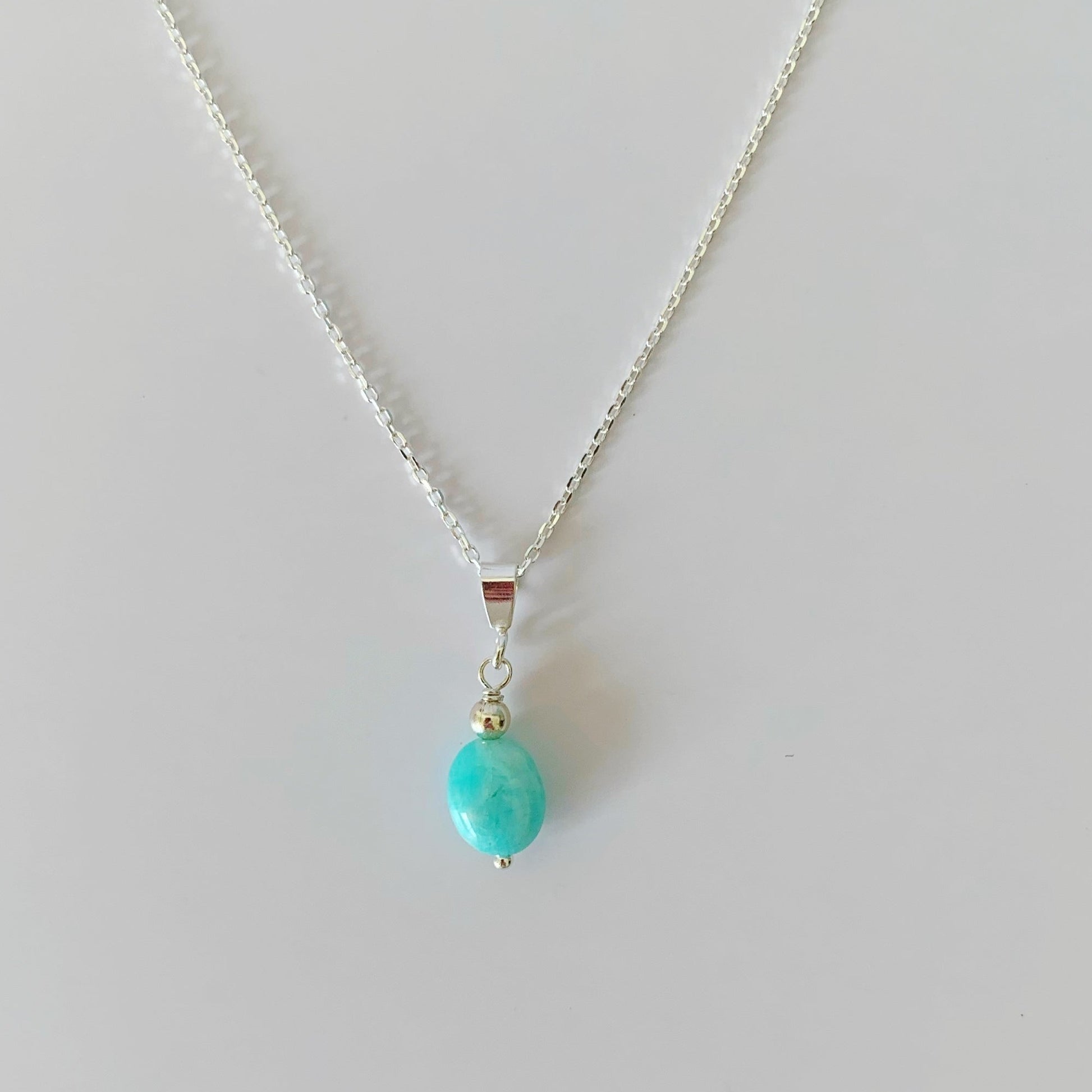 The Mermaids and madeleines laguna pendant is created with an oval amazonite drop on sterling silver chain. this necklace is photographed on a white table