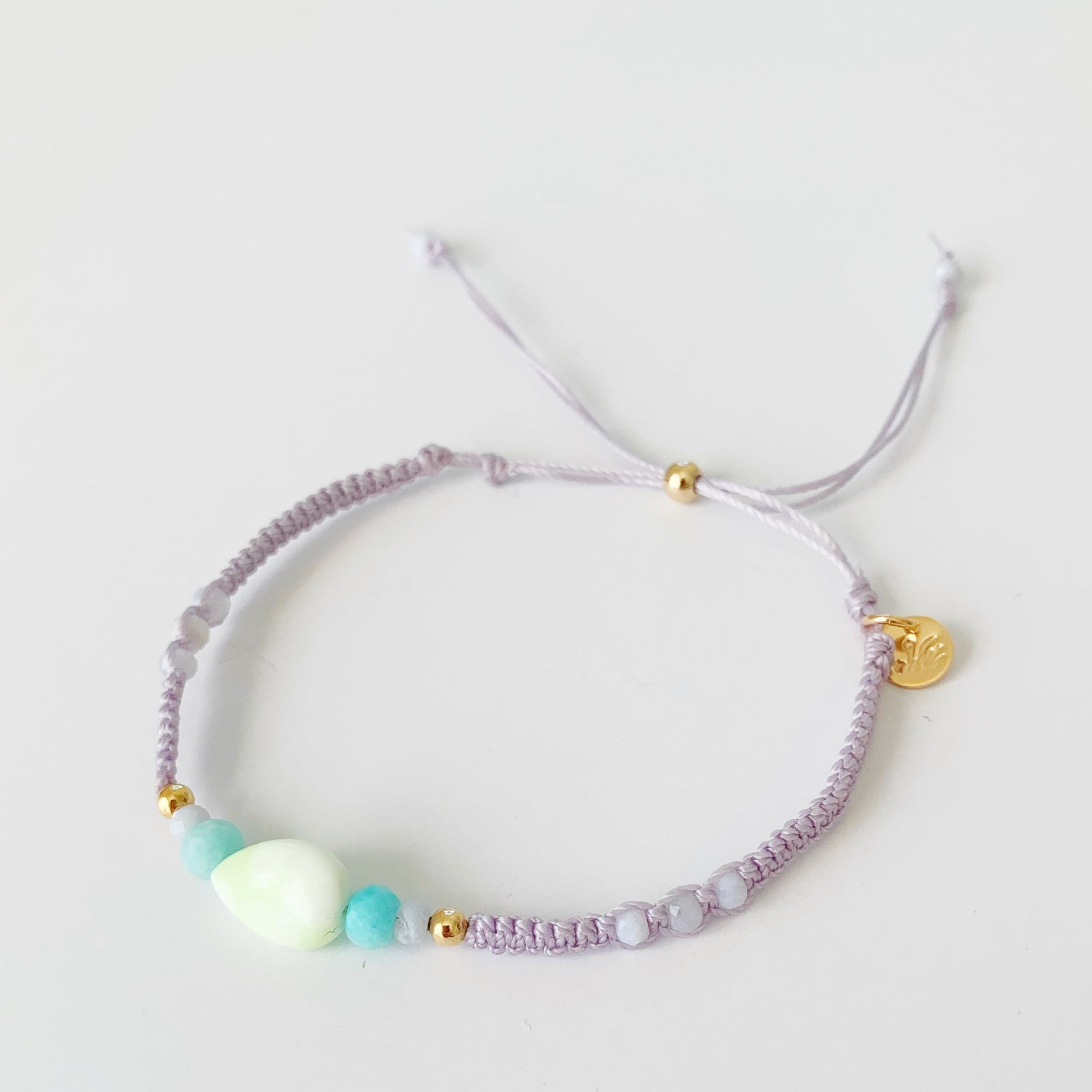 a top view of the coastal haze lavender macrame bracelet photographed on a white backdrop