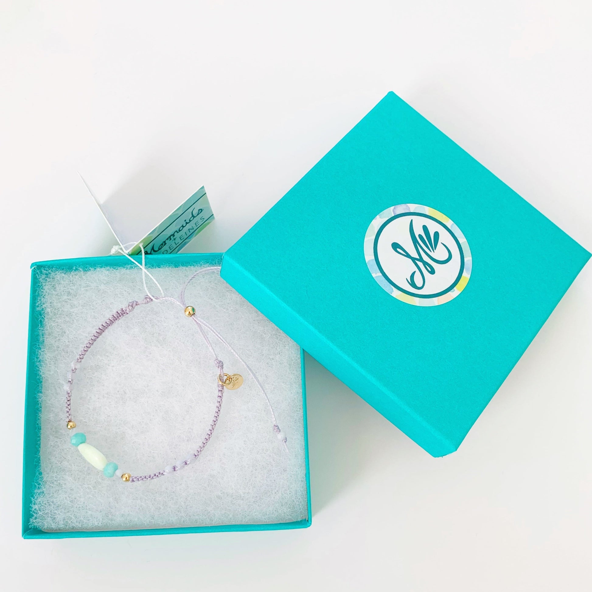 The coastal haze captiva macrame bracelets photographed in a teal mermaids and madeleines gift box on a white surface