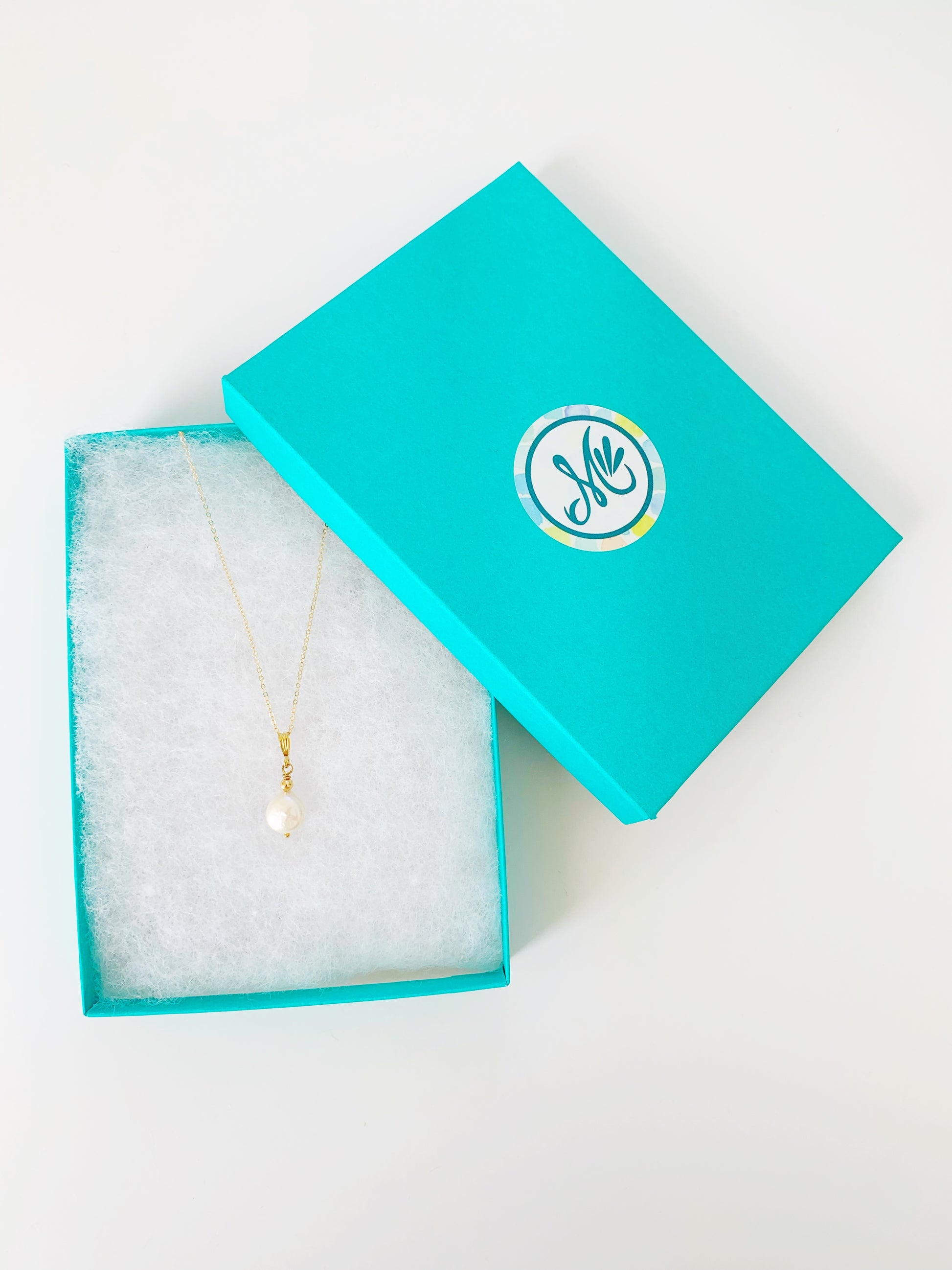 Newport freshwater coin pearl with 14k gold filled chain and findings pictured here in a cotton lined teal gift box on a white table